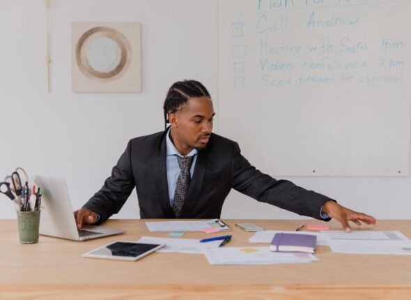 man sitting at his desk reaching for documents