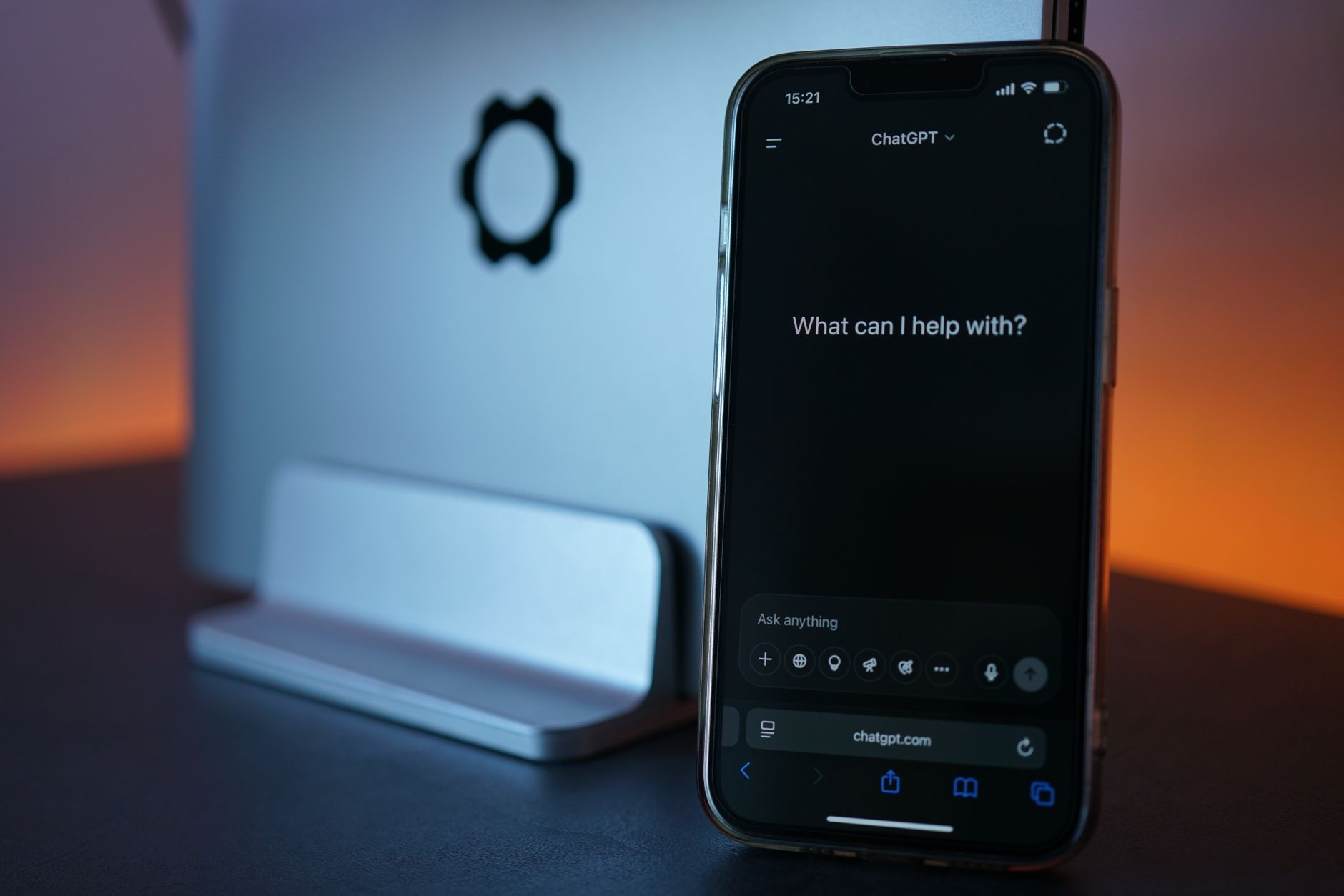 smartphone displaying chat interface with laptop
